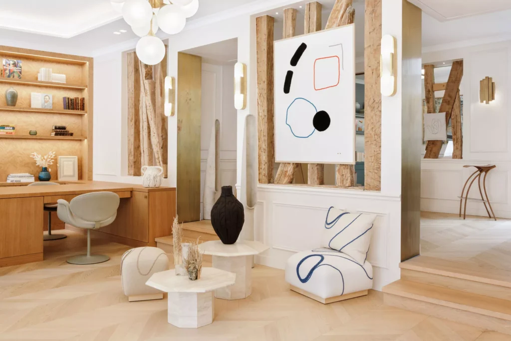 Modern Parisian interior with geometric travertine side tables, sculptural decor, and minimalist lounge seating at a design showcase.