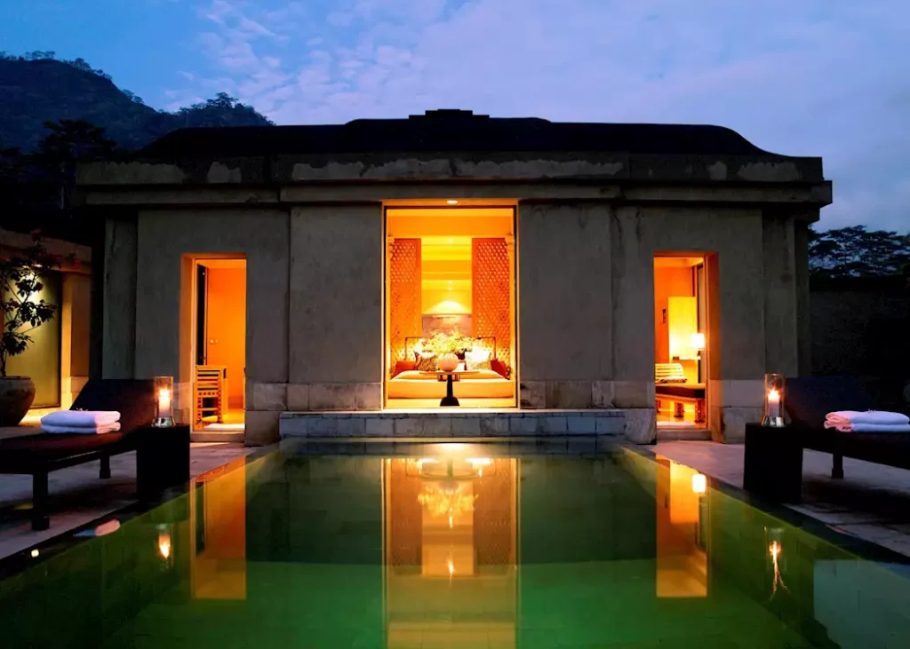 Amanjiwo resort in Yogyakarta with glowing lantern-lit pavilion, private pool, and Javanese-inspired architecture at dusk.
