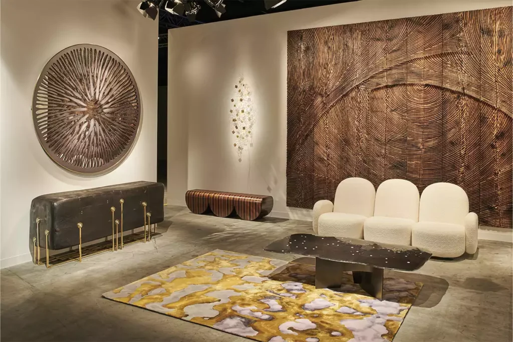 Contemporary design installation at Art Basel Miami with sculptural furniture, textured wall art, and statement rug.