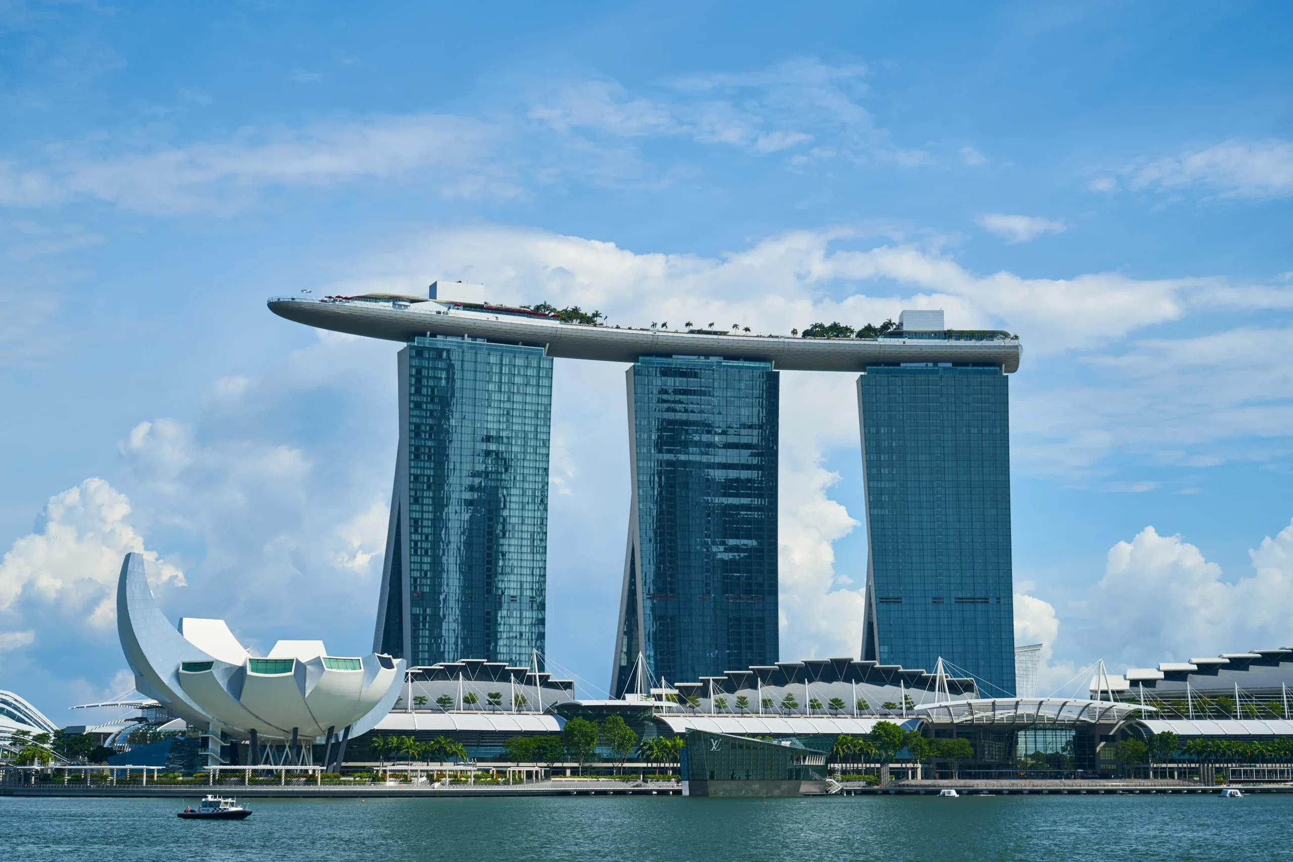 Iconic Marina Bay Sands hotel in Singapore with three glass towers topped by the SkyPark infinity pool overlooking the waterfront.