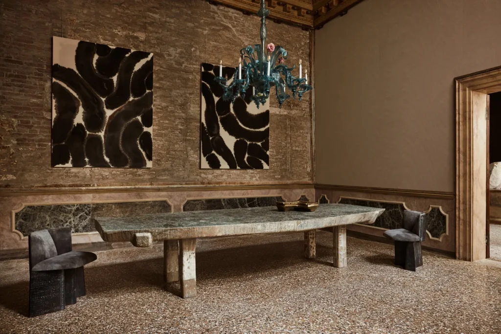 Minimalist dining room with stone table, abstract art, and antique walls inside a historic Italian palazzo.