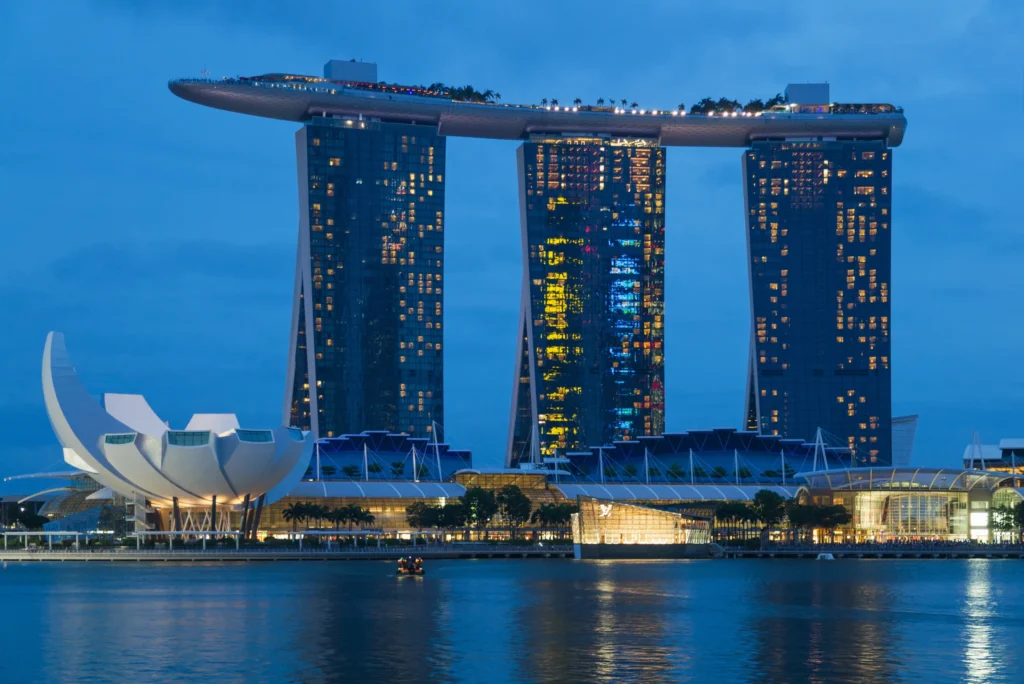 Iconic Marina Bay Sands hotel in Singapore with three glass towers topped by the SkyPark infinity pool overlooking the waterfront.