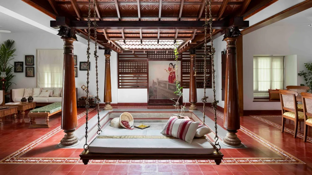 Traditional Kerala home interior with wooden pillars, swing bed, and open courtyard design.