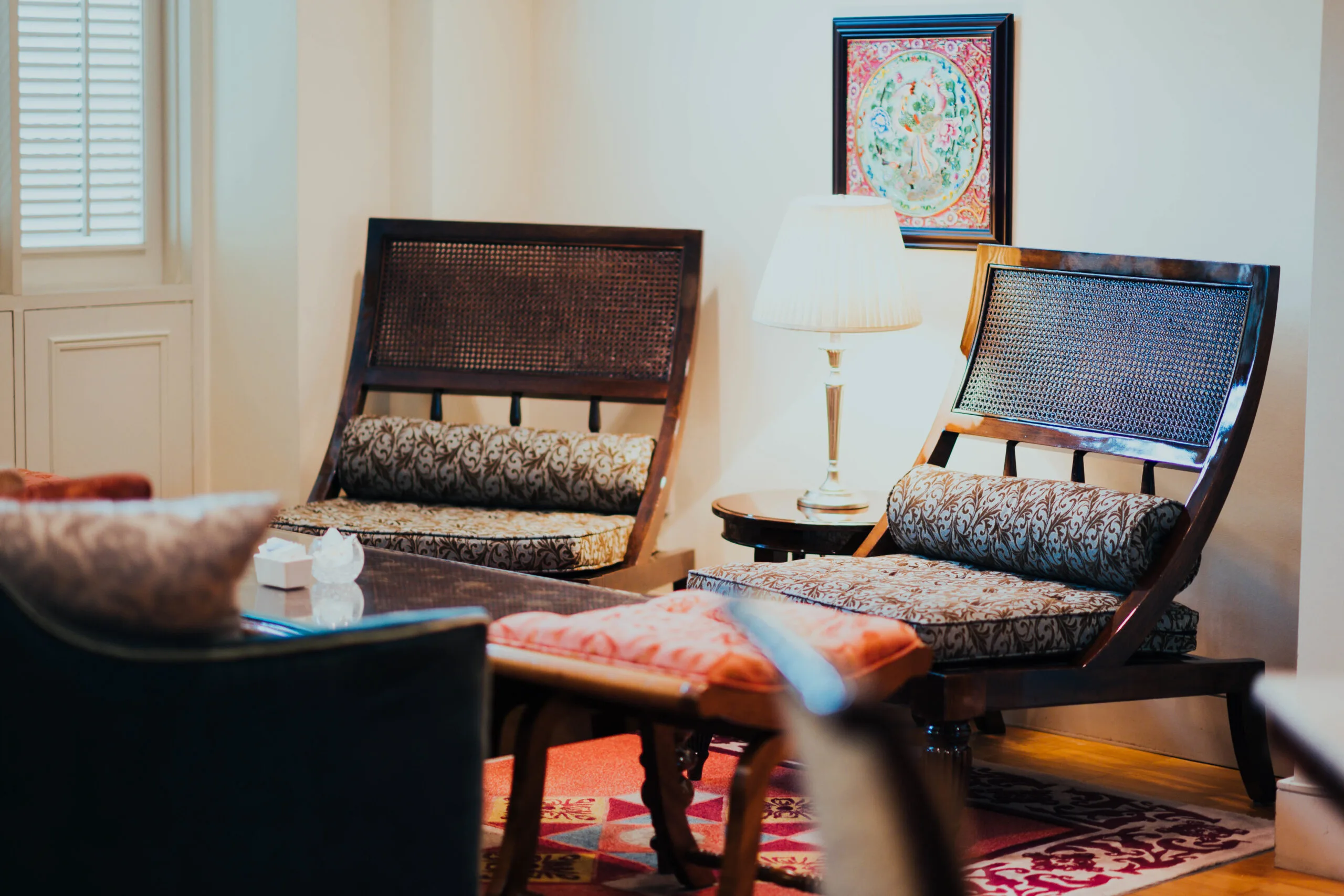 Cultural-inspired living room with patterned chairs, wooden furniture, and decorative accents.