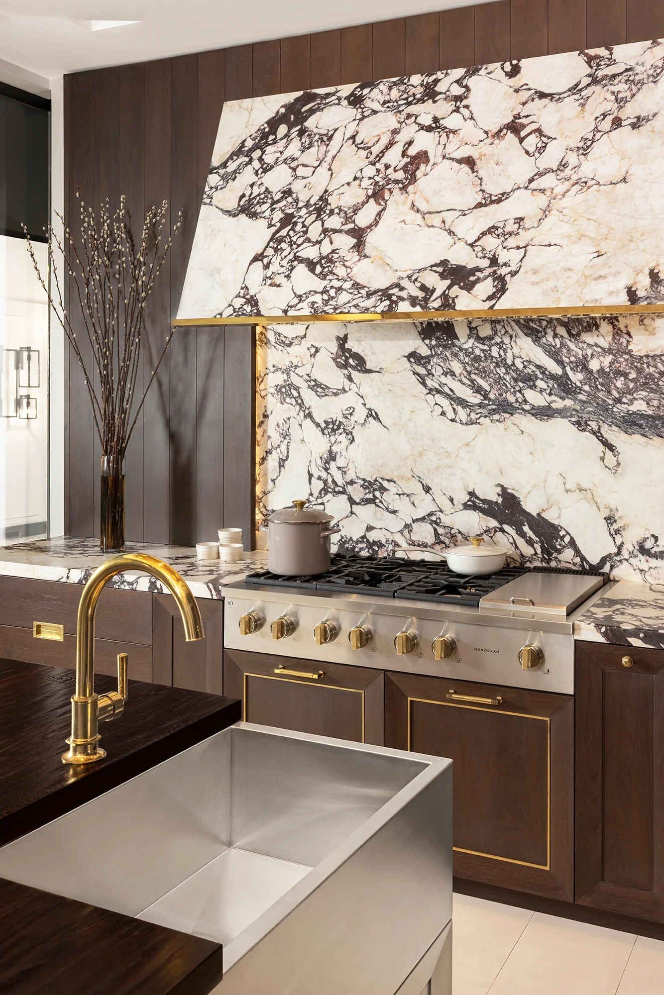 Modern kitchen interior with Calacatta marble flooring, wooden cabinetry, and a sleek minimalist design.