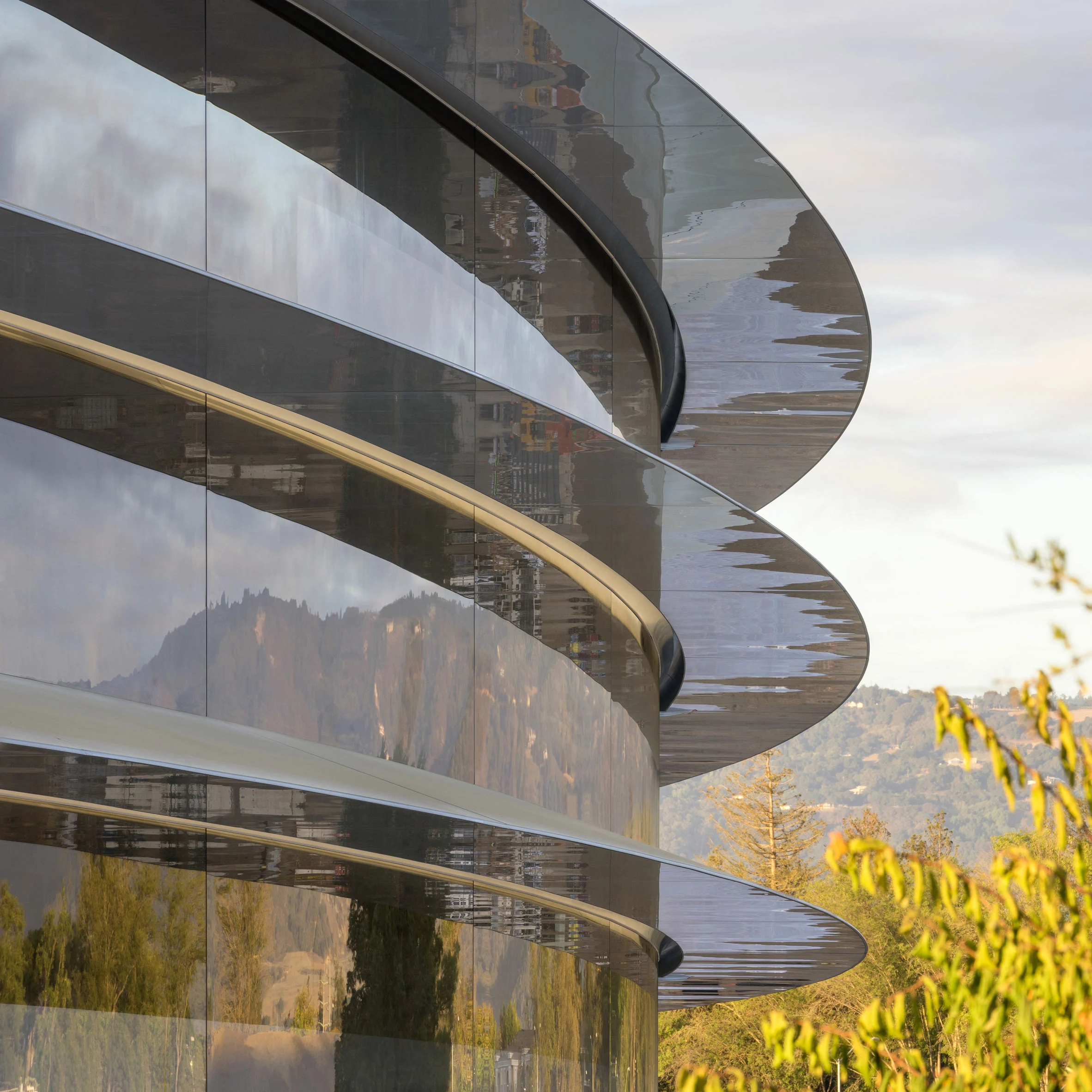 Close-up of curved glass architecture reflecting natural surroundings — an exploration of light, reflection, and the harmony between structure and landscape.