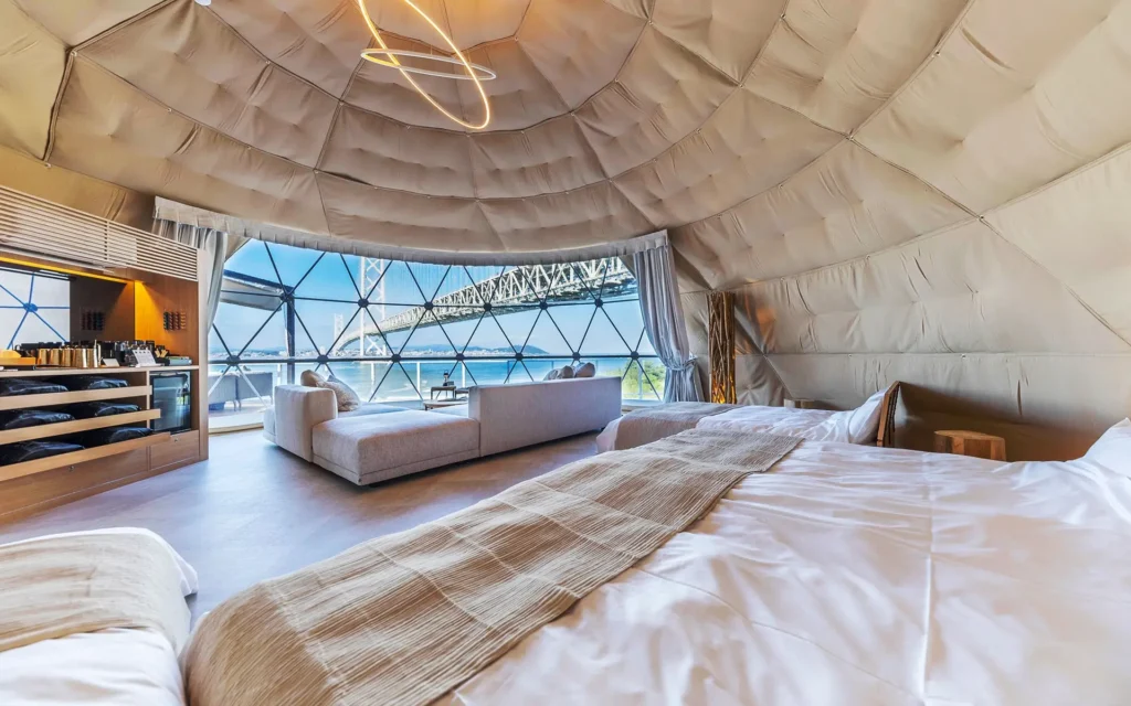 Modern geodesic dome suite with panoramic water views and contemporary minimalist design.