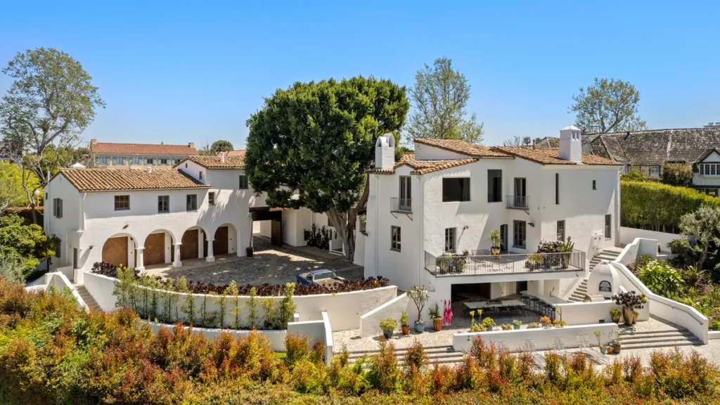 Contemporary hillside mansion in Los Angeles with terrace pool, palm trees, and panoramic canyon views.