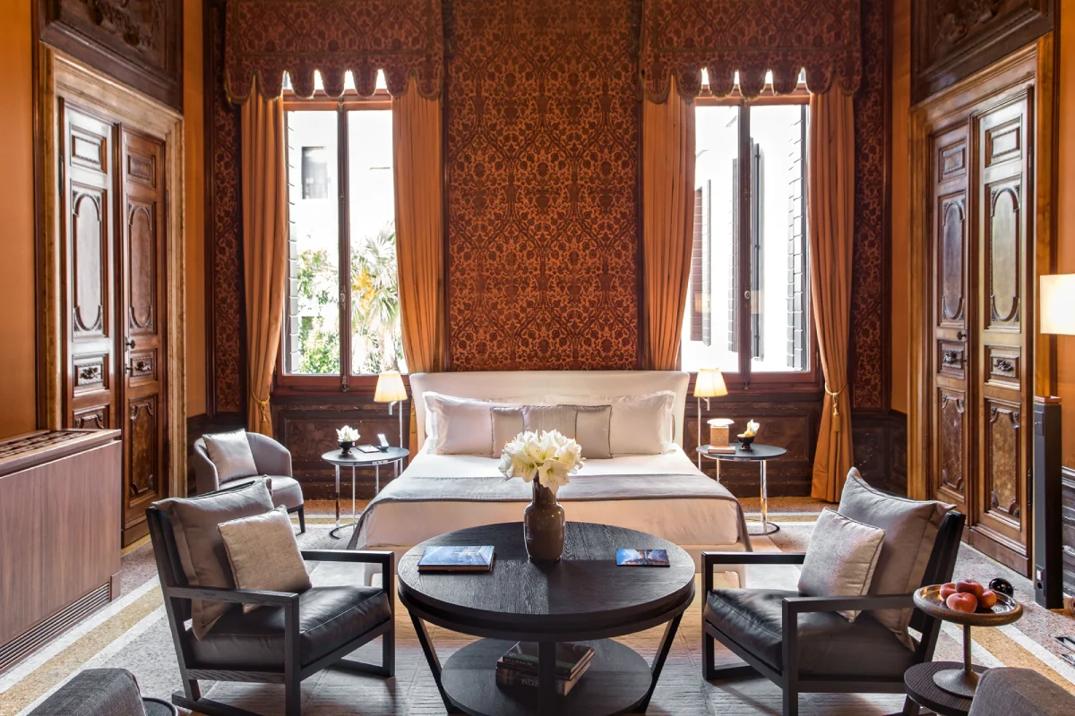 A luxurious bedroom with a center table and chairs