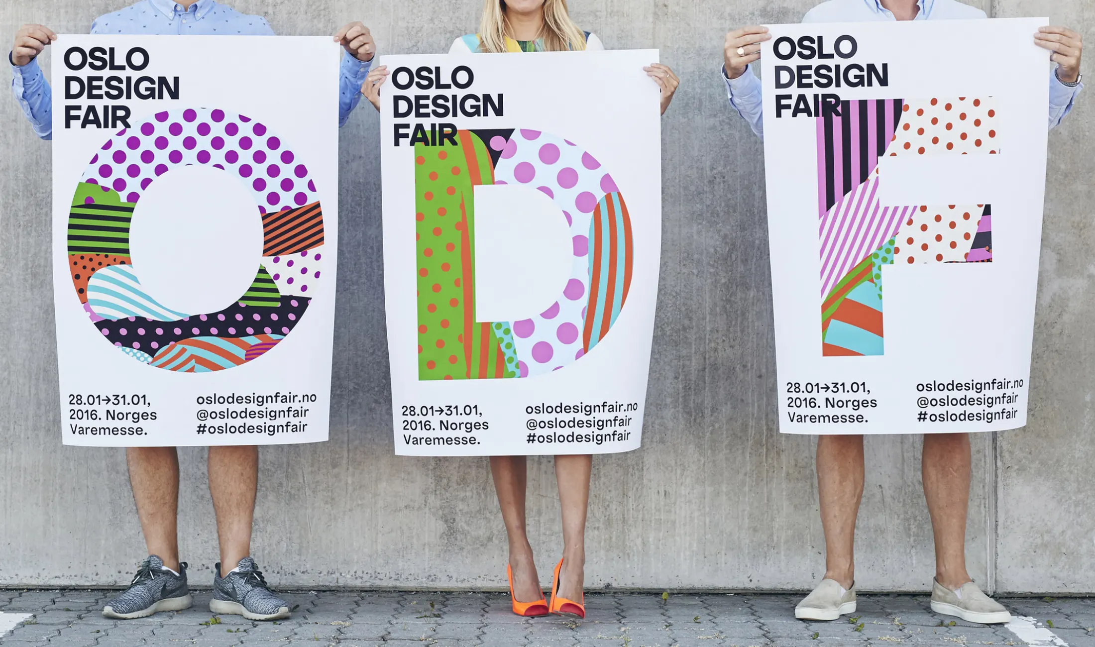 Three people holding colourful Oslo Design Fair posters featuring bold geometric patterns and typography.