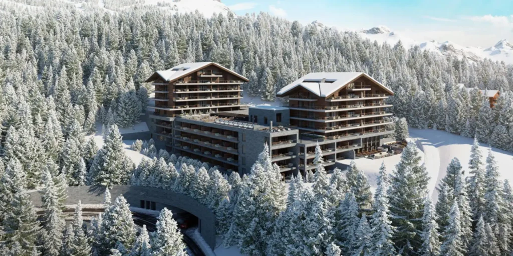 Six Senses Crans Montana surrounded by snow-covered pine forests and mountain peaks, showcasing contemporary chalet inspired architecture in Switzerland.